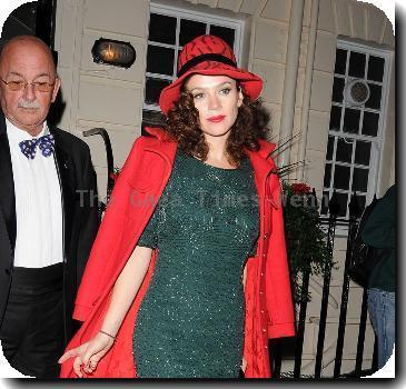 Anna Friel outside the Theatre Royal Haymarket, where she stars in 'Breakfast At Tiffany's wearing a red hat and matching red coat with a green sequined dressLondon. England