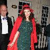 Anna Friel outside the Theatre Royal Haymarket, where she stars in 'Breakfast At Tiffany's wearing a red hat and matching red coat with a green sequined dressLondon. England