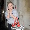 Diana Vickers former 'X factor' contestant leaving the Vaudeville Theatre carrying a large striped handbag and her mobile phone. London.