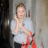 Diana Vickers former 'X factor' contestant leaving the Vaudeville Theatre carrying a large striped handbag and her mobile phone. London.