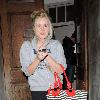 Diana Vickers former 'X factor' contestant leaving the Vaudeville Theatre carrying a large striped handbag and her mobile phone. London.