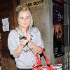 Diana Vickers former 'X factor' contestant leaving the Vaudeville Theatre carrying a large striped handbag and her mobile phone. London.