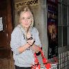 Diana Vickers former 'X factor' contestant leaving the Vaudeville Theatre carrying a large striped handbag and her mobile phone. London.