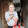 Diana Vickers former 'X factor' contestant leaving the Vaudeville Theatre carrying a large striped handbag and her mobile phone. London.