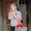 Diana Vickers former 'X factor' contestant leaving the Vaudeville Theatre carrying a large striped handbag and her mobile phone. London.