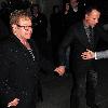 Elton John and David Furnish holding hands as they leave Scotts restaurant.