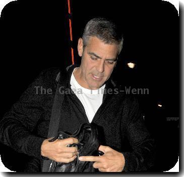 George Clooney in blue jeans, heavy boots and a black leather jacket arrives at his hotel.