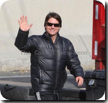 Tom Cruise in a black puffa jacket waves to fans during filming on the set of his new movie 'Wichita' Boston.