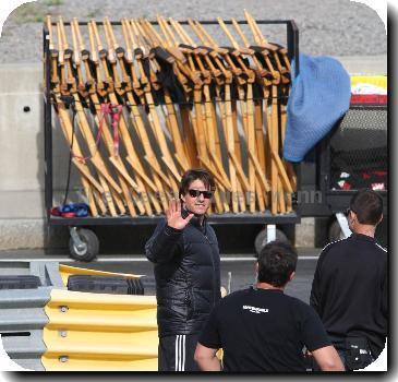 Tom Cruise in a black puffa jacket waves to fans during filming on the set of his new movie 'Wichita' Boston.