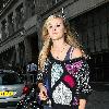 Fearne Cotton signs autographs as she leaves BBC Radio studios carrying a pair of blue headphones and wearing feathers in her hair.