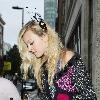 Fearne Cotton signs autographs as she leaves BBC Radio studios carrying a pair of blue headphones and wearing feathers in her hair.