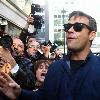 Robbie Williams signing autographs for fans as he arrives at Radio one studios.