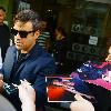 Robbie Williams signing autographs for fans as he arrives at Radio one studios.