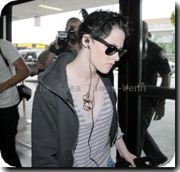 Kristen Stewart  listening to her iPod as she arrives at LAX airport to catch an Alaska Airlines flight. Los Angeles, California.