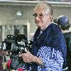 George Hamilton arriving at LAX airport to catch a flight--he turned the tables on a paparazzo by borrowing his camera and laughing as he filmed the snapper..