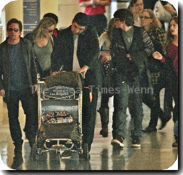 Michael J Fox arrives at LAX airport with his family and get in their waiting van.