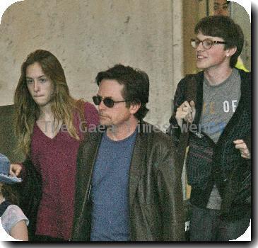 Michael J Fox arrives at LAX airport with his family and get in their waiting van.