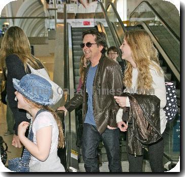 Michael J Fox arrives at LAX airport with his family and get in their waiting van.