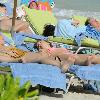 Brian Ray, guitarist for Paul McCartney, and his girlfriend enjoy the sun on a beach.