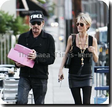 Johnny Hallyday carries two pink boxes as he leaves La Conversation Cafe with his wife Laetitia in West Hollywood.Los Angeles, California.