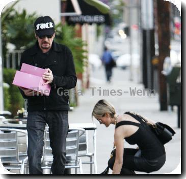 Johnny Hallyday carries two pink boxes as he leaves La Conversation Cafe with his wife Laetitia in West Hollywood.Los Angeles, California.