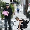 Johnny Hallyday carries two pink boxes as he leaves La Conversation Cafe with his wife Laetitia in West Hollywood.Los Angeles, California.
