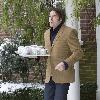 Jonathan Ross 
carries tea to journalists outside his house after it was announced he would be leaving the BBC.