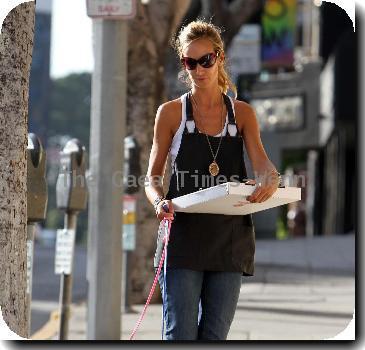 Lady Victoria Hervey grabs a pizza for lunch and chats on her mobile phone while taking her dogs for a walk. Los Angeles, California.