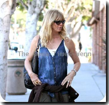 Goldie Hawn wearing baggy trousers and an oversized waistcoat together with a cardigan tied around her waist, pays a parking meter with a credit card on her way to a pharmacy in Santa Monica..