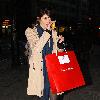 Gemma Arterton arrives at a theatre eating an apple and carrying a large shopping bag.
London, England.