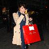 Gemma Arterton arrives at a theatre eating an apple and carrying a large shopping bag.
London, England.