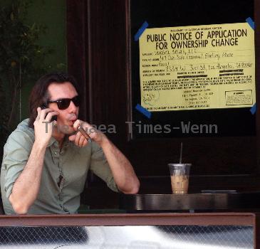 Lukas Haas enjoying a cigar while talking on his phone outside his new bar in West Hollywood.Los Angeles.