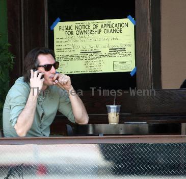 Lukas Haas enjoying a cigar while talking on his phone outside his new bar in West Hollywood.Los Angeles.