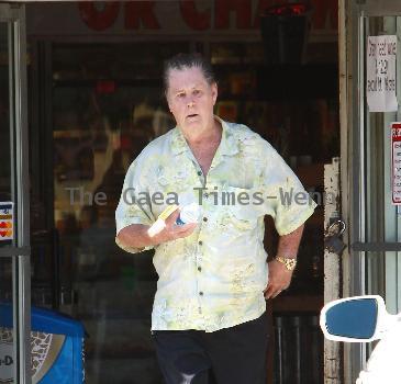 Beach Boys legend Brian Wilson saunters back to his car after buying a bottle of water at a roadside market. 
Los Angeles, California.