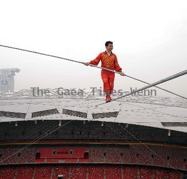 AHDILI LIVES THE HIGH-WIRE LIFE Thrill-seeker Ahdili gingerly crosses a tightrope high above China's famous Bird's Nest – as he bids to spend 60 days living in a tiny cabin on the roof.  Daredevil Ahdili, hailed as the Prince of Tightrope Walking in his native country, crossed from one side of the Beijing National Stadium to the other as nervous onlookers watched from below.  He is planning a feat of endurance – by living in a nine-metre box on top of the arena for the next two months to set a new world record. (ZN/WN)