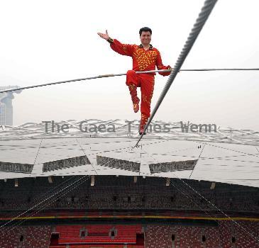 AHDILI LIVES THE HIGH-WIRE LIFE Thrill-seeker Ahdili gingerly crosses a tightrope high above China's famous Bird's Nest – as he bids to spend 60 days living in a tiny cabin on the roof.  Daredevil Ahdili, hailed as the Prince of Tightrope Walking in his native country, crossed from one side of the Beijing National Stadium to the other as nervous onlookers watched from below.  He is planning a feat of endurance – by living in a nine-metre box on top of the arena for the next two months to set a new world record. (ZN/WN)