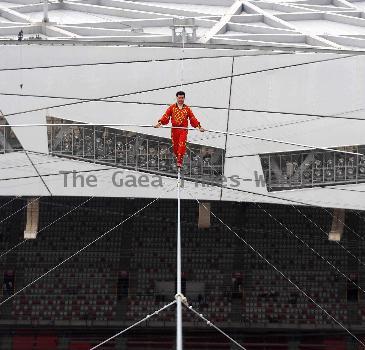 AHDILI LIVES THE HIGH-WIRE LIFE Thrill-seeker Ahdili gingerly crosses a tightrope high above China's famous Bird's Nest – as he bids to spend 60 days living in a tiny cabin on the roof.  Daredevil Ahdili, hailed as the Prince of Tightrope Walking in his native country, crossed from one side of the Beijing National Stadium to the other as nervous onlookers watched from below.  He is planning a feat of endurance – by living in a nine-metre box on top of the arena for the next two months to set a new world record. (ZN/WN)