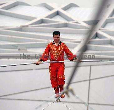 AHDILI LIVES THE HIGH-WIRE LIFE Thrill-seeker Ahdili gingerly crosses a tightrope high above China's famous Bird's Nest – as he bids to spend 60 days living in a tiny cabin on the roof.  Daredevil Ahdili, hailed as the Prince of Tightrope Walking in his native country, crossed from one side of the Beijing National Stadium to the other as nervous onlookers watched from below.  He is planning a feat of endurance – by living in a nine-metre box on top of the arena for the next two months to set a new world record. (ZN/WN)