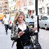 Susannah Constantine text messaging on her mobile phone as she strolls around central London. London.