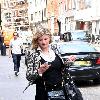 Susannah Constantine text messaging on her mobile phone as she strolls around central London. London.