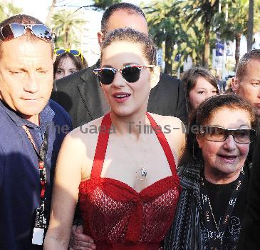 Marion Cotillardis escorted by bodyguards as she walks along the Croisette during the 63rd Cannes Film FestivalCannes.