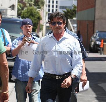 Sylvester Stallone 
signs an autograph for a fan while out and about in Beverly Hills smoking a cigar.
Los Angeles, California, USA.