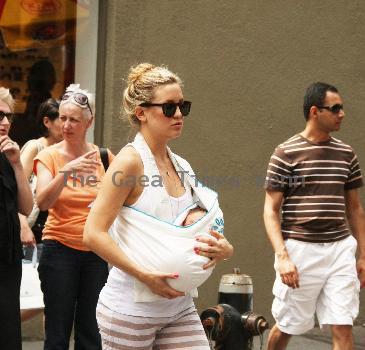 Kate Hudson walking with a friends baby on the way to Giggles baby store in Soho New York.