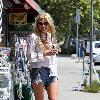 Sophie Monkhas breakfast at Kings Road Cafe wearing cut off denim shorts that appear a few sizes too large. Los Angeles.
