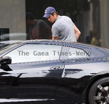 Vernon Kay arrives at the BBC Radio 1 studios to present his weekend show, wearing a Chicago Bears cap and t-shirt, white shorts and flip flops. 
London, England.