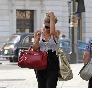 Emma Rigby cant resist letting down her long blonde hair, when she spots our photographer, as she strolls through central London, carrying two large handbags. London.