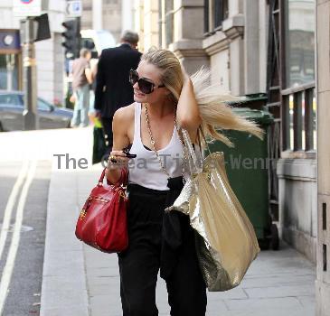 Emma Rigby cant resist letting down her long blonde hair, when she spots our photographer, as she strolls through central London, carrying two large handbags. London.