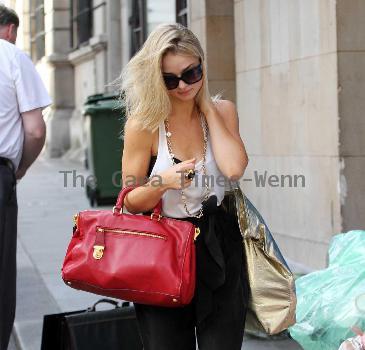 Emma Rigby cant resist letting down her long blonde hair, when she spots our photographer, as she strolls through central London, carrying two large handbags. London.