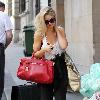 Emma Rigby cant resist letting down her long blonde hair, when she spots our photographer, as she strolls through central London, carrying two large handbags. London.