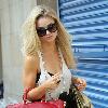 Emma Rigby cant resist letting down her long blonde hair, when she spots our photographer, as she strolls through central London, carrying two large handbags. London.